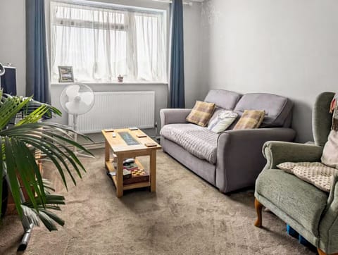 Light-filled lounge with sofa, armchair and coffee table