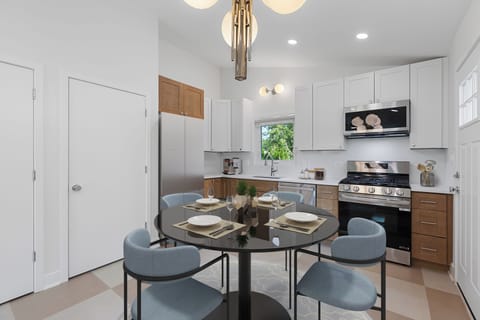 Open eat-in kitchen with quartz counters, new appliances, and breakfast bar.