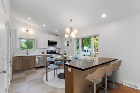 Open eat-in kitchen with quartz counters, new appliances, and breakfast bar.
