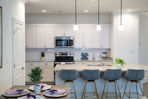 Kitchen with 4 barstools and table that seats 4.