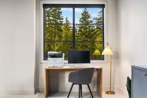 Settle in for focus — a dedicated desk, monitor, and printer at the ready.