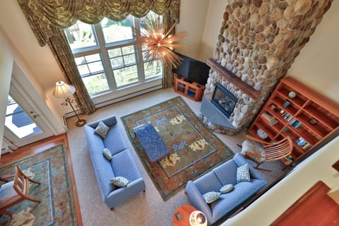 The Great Room at Stonefire Chalet features a beautiful stone fireplace, stylish décor, comfortable seating and a Smart TV.