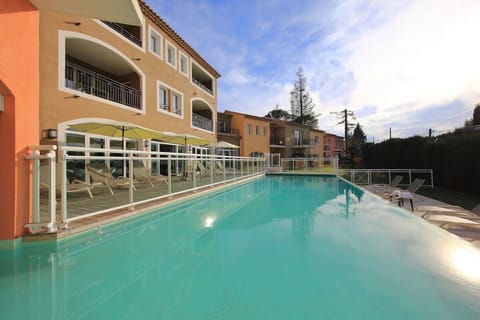 Dive into the sparkling pool framed by relaxing loungers.