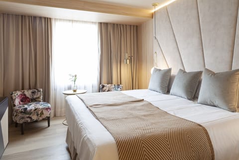 Relax by the window with cozy seating and soft drapery.