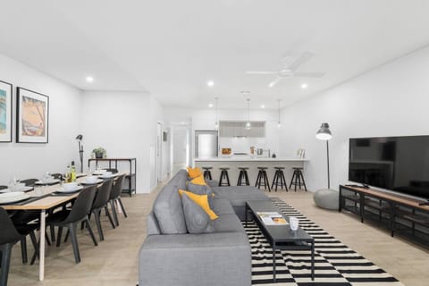 Gather for meals around the spacious dining table or perch at the oversized breakfast bar beneath pendant lights in the social hub designed for comfort and connection.