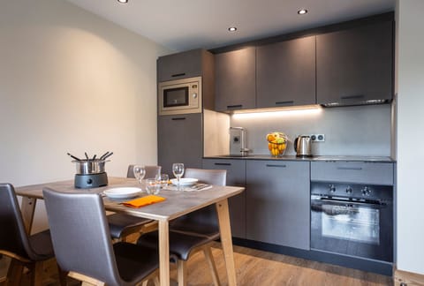 Modern dining space adjacent to a fully equipped kitchen, blending form and function effortlessly.