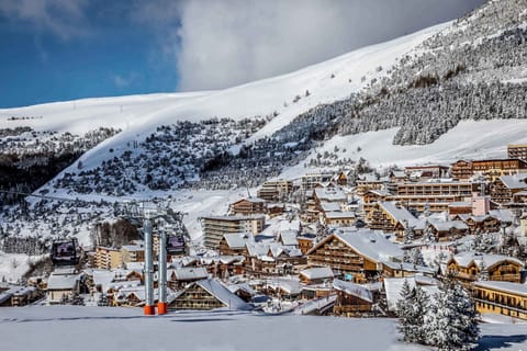 An authentic ski resort scene—snowy rooftops, gondolas, and endless powdery trails.