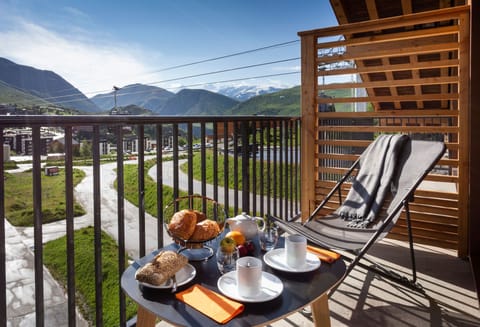 Alpine breakfast nook on a private balcony with stunning views of the valley and peaks.