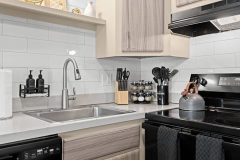 Modern kitchen with sleek finishes, stainless steel sink, and quality cookware.