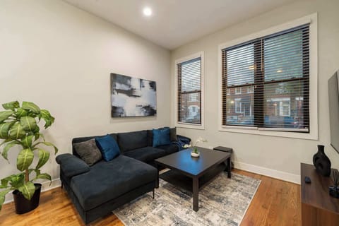 Sunlit living room w/ cozy sofa & warm wood floors