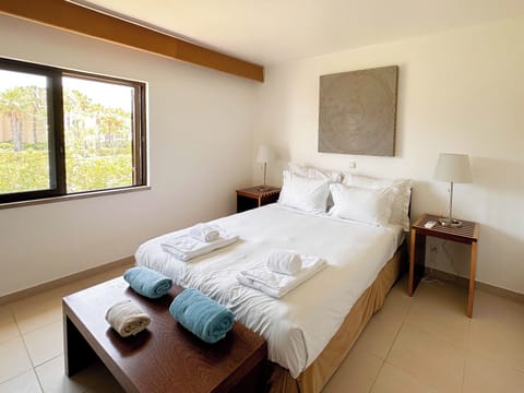 Recharge in crisp linens beside a sunny garden-view window.