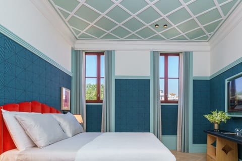 Unwind beneath soaring ceilings in this vibrant, design-forward bedroom.