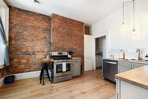 Cook in a fully equipped kitchen with a charming brick wall, complete with all essentials, including a coffee maker for your daily caffeine fix. A perfect blend of rustic and modern, designed for comfort and convenience.