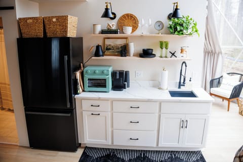 Kitchenette equipped with refrigerator, sink, air fryer-toaster oven, and Keurig coffee maker