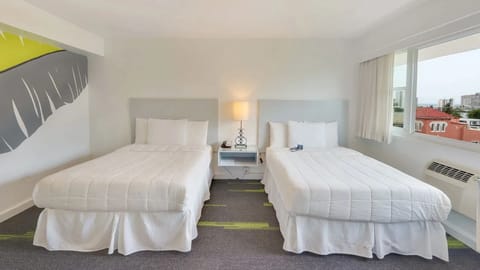 Stretch out on two plush beds beside a sunny window.