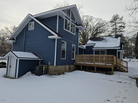 Back of house showing new deck with patio door to main room.