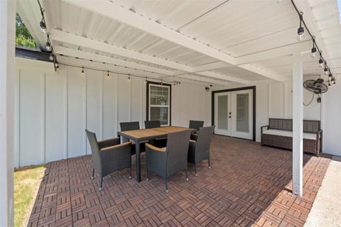 Lighted, covered patio with BBQ and large fenced yard for playing outdoor games.