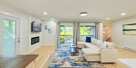 Relax in this open living room featuring sofa, Tv, Fireplace with pick view lake