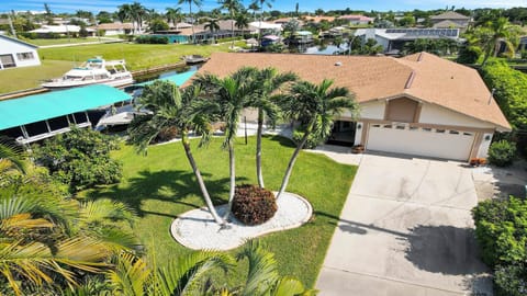 Villa Love Bird in Cape Coral features a well-kept garden, tropical palm trees, and direct canal access – perfect for boat trips from your private dock.