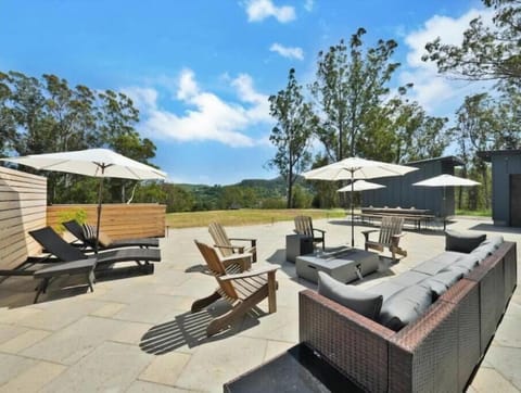 French doors open to outdoor dining, lounge seating, fireplace table & lawn.