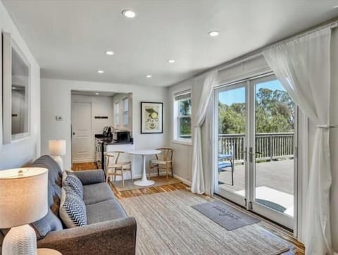 Living room with screened French doors opening to deck for indoor/outdoor flow.