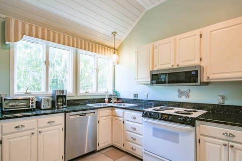 The kitchen features an electric range, microwave, double sink, dishwasher, toaster oven and drip coffee maker.