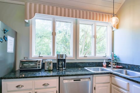 The kitchen features shiplap ceilings, wonderful natural light and white cabinets.