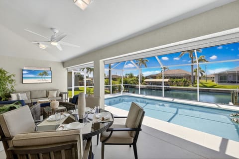 A spacious lanai with a TV, overlooking a sparkling HEATED pool and GULF ACCESS canal.