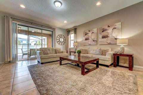 Spacious living room with comfortable seating and natural light from sliding glass doors.