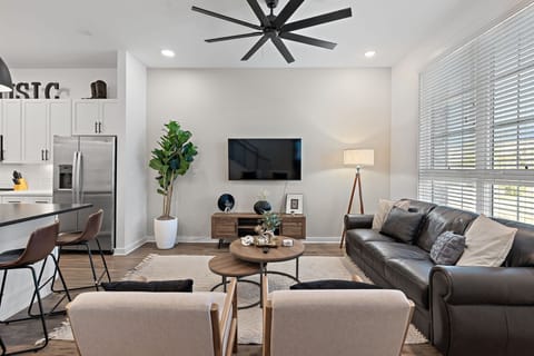Stylish, clutter-free living room with mounted TV and leather seating.