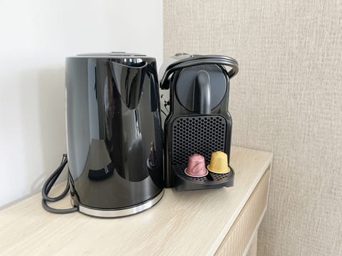 Modern kitchen setup with gas stove, Nespresso machine, and electric kettle.