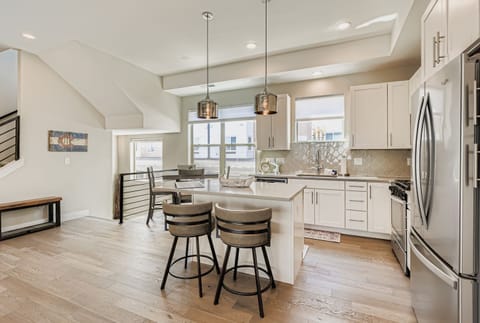 Your spacious kitchen awaits with gleaming countertops, modern appliances, and a breakfast bar perfect for morning coffee or casual meals together.