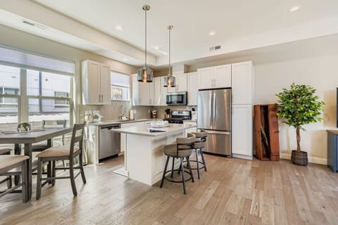 Your bright, modern kitchen invites culinary adventures with stainless steel appliances, sleek white cabinets, and a convenient breakfast bar for morning coffee.