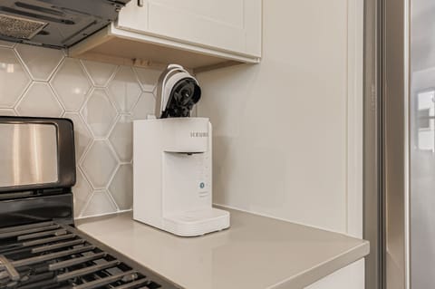 Start your mornings right with this convenient coffee station, perfectly positioned in your stylish kitchen for easy brewing.