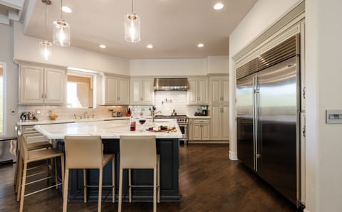 Fully equipped kitchen with stainless steal appliances, mini wine cooler, ice maker, and a kitchen island with bar seating for 4 guests.