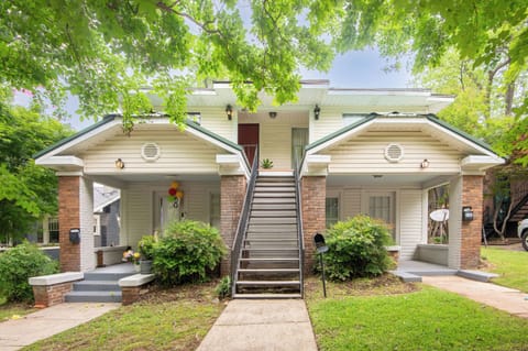 Charming exterior with inviting curb appeal – A cozy duplex-style home with covered front entry and a shared green lawn.