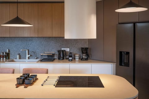 The adjacent kitchen is fully equipped with high-end GORENJE appliances, while a central island with seating for twelve adds a casual dining spot.