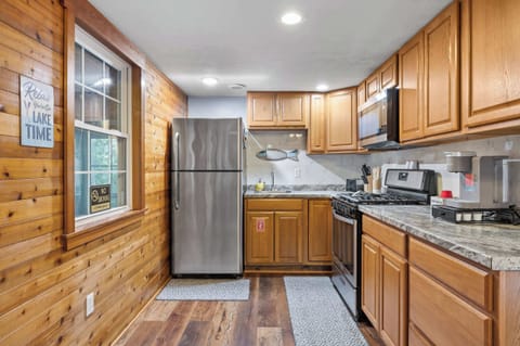 Kitchen: Whip up delicious meals in our charming, fully-equipped kitchen! With warm wood paneling and all the essentials, you'll feel right at home as you cook up your favorite dishes. 'Relax, It's Lake Time!'