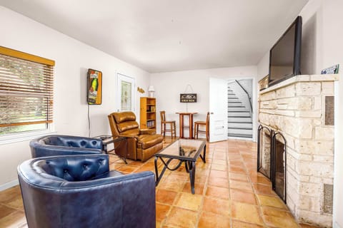 Bright and inviting living space with comfy seating, a stone fireplace, and plenty of room to relax.