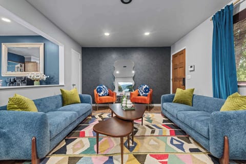 Bright open-concept living room with cozy blue sofas and modern décor in Westminster Denver home.