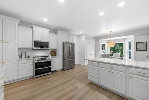 Enjoy a full kitchen with all-white cabinets, stainless steel appliances