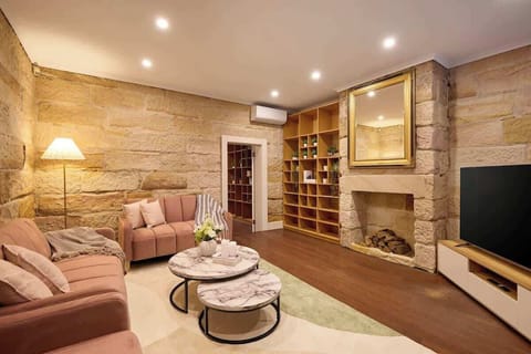 Stunning main living area with original sandstone fireplace, smart TV and custom shelving. Perfect blend of 19th-century heritage charm and modern comfort in historic Woolloomooloo.