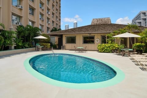Unwind poolside on sunny loungers in a serene courtyard.