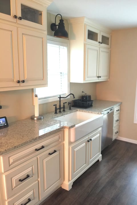 The kitchen features a large farmhouse sink. Lots of kitchenware for cooking.