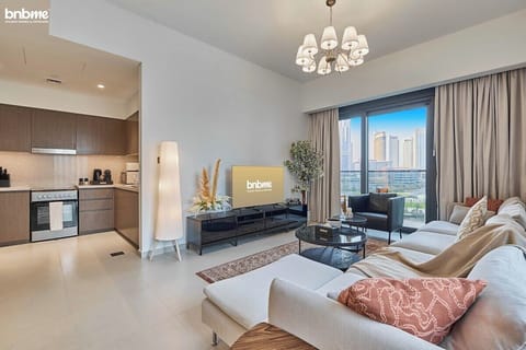 Modern living room with L-shaped sofa, smart TV, designer accents, and balcony access offering panoramic Downtown Dubai views—perfect for relaxing or entertaining.