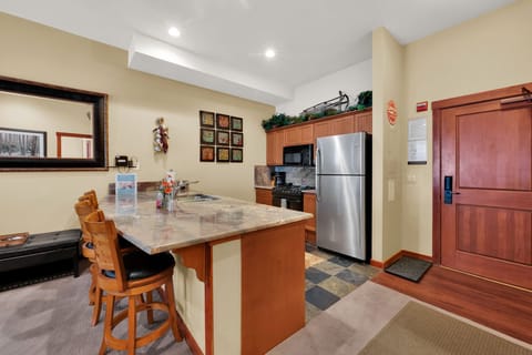Fully stocked kitchen and island with bar stools and electric stove. Perfect for cooking any meal!