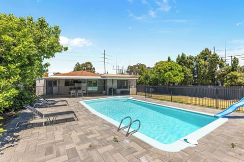 Enjoy our large, refreshing swimming pool with a fun slide, sun loungers, and a great view of the house and covered patio.