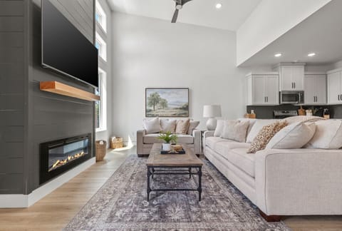 Spacious living room with vaulted ceilings, cozy fireplace, and plenty of natural light.