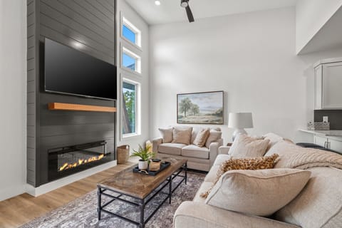 Spacious living room with vaulted ceilings, cozy fireplace, and plenty of natural light.