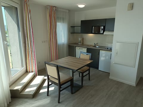 This bright, inviting kitchen and dining area combines functionality with style, showcasing modern appliances and ample natural light.